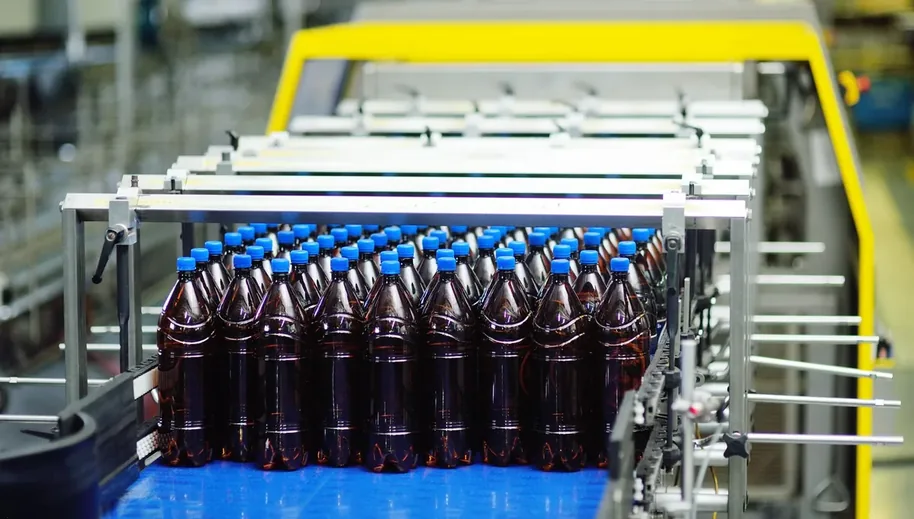 Garrafas em esteira de linha de envase de bebidas