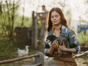 Mulher com um animal filhote nos braços em área aberta